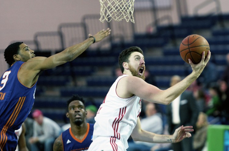 Ryan Kelly of the Maine Red Claws drives to the basket as Shaquille Harrison of the Northern Arizona Suns attempts to block Kelly's shot during Thursday's game at the Portland Expo. Maine won, 97-91. (Photo by Shawn Patrick Ouellette/Staff Photographer)