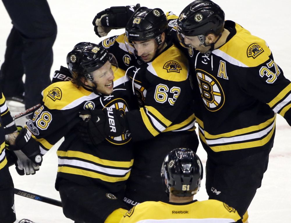 Boston's David Pastrnak, 88, celebrates his first-period goal with Brad Marchand, 63, and Patrice Bergeron in Thursday's game against the San Jose Sharks, in Boston.