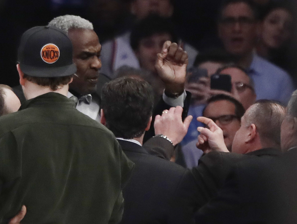 Charles Oakley, a former player for the New York Knicks, exchanges words with a security guard Wednesday night at a Knicks game. Oakley was arrested for three counts of misdemeanor assault and one count of criminal trespass.