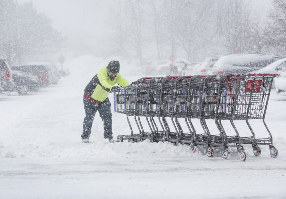 Mike Scarpelli collects shopping carts at Hannaford in Portland during Thursday's snowstorm. Hardware stores reported brisk sales of shovels and snowblowers ahead of the storm, which dumped 7.5 inches of snow in Portland and more in York County. At Portland International Jetport, 70 percent of flights were canceled Thursday, and more travel disruptions are expected as another storm moves in Sunday night.