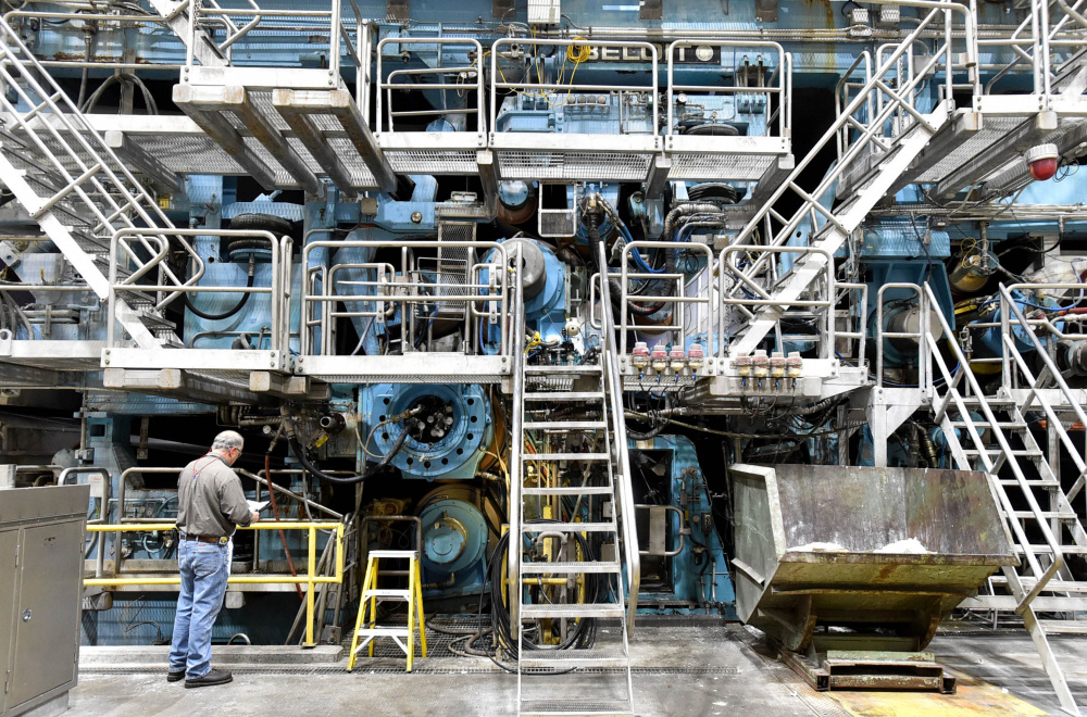 A worker inspects machine No. 2 on Friday at the Sappi paper mill in Skowhegan. Sappi has announced a $165 million upgrade of another paper machine at the Somerset County facility.