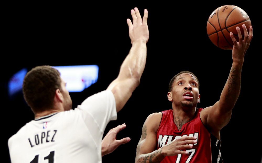 Miami guard Rodney McGruder goes up for a shot against Brooklyn center Brook Lopez during the first half of their game Friday night in New York. The Heat captured their 13th straight win, 108-99.