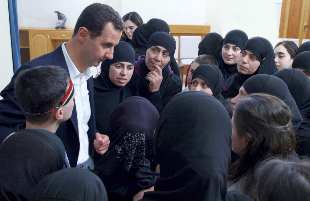 Syrian President Bashar Assad meets with former hostages released in a prisoner exchange with rebels in Damascus, Syria. Assad appears to be immune to consequences as evidence of atrocities continues to mount.