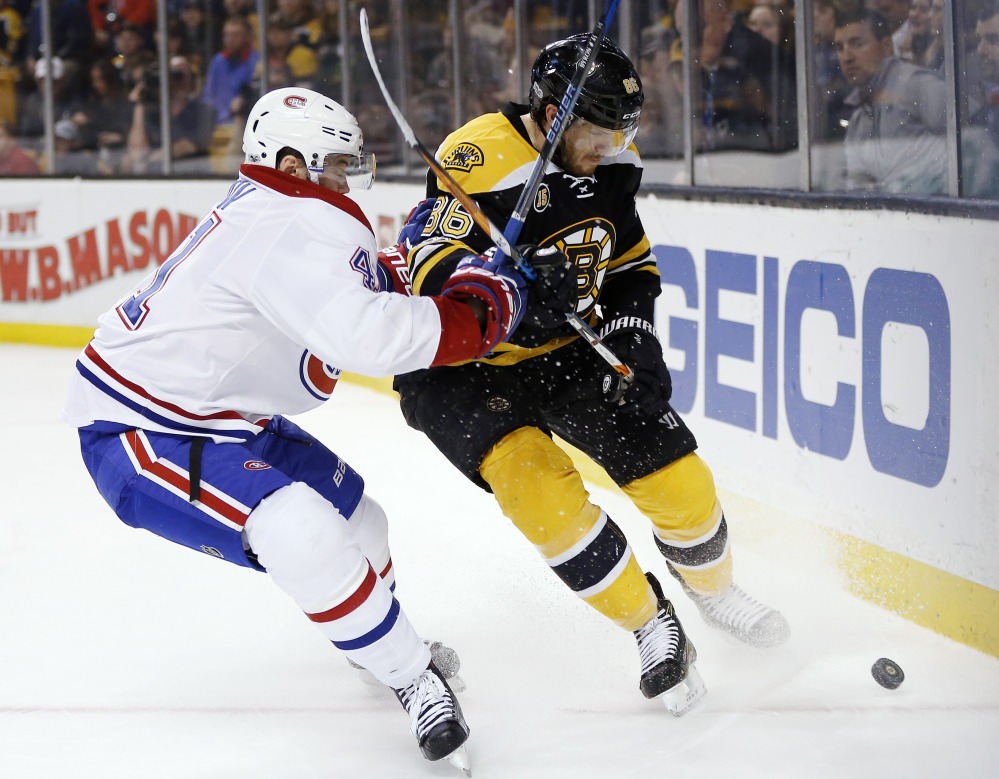Montreal Canadiens' Paul Byron and Bruins' Kevan Miller battle for the puck during the first period in Boston on Sunday.