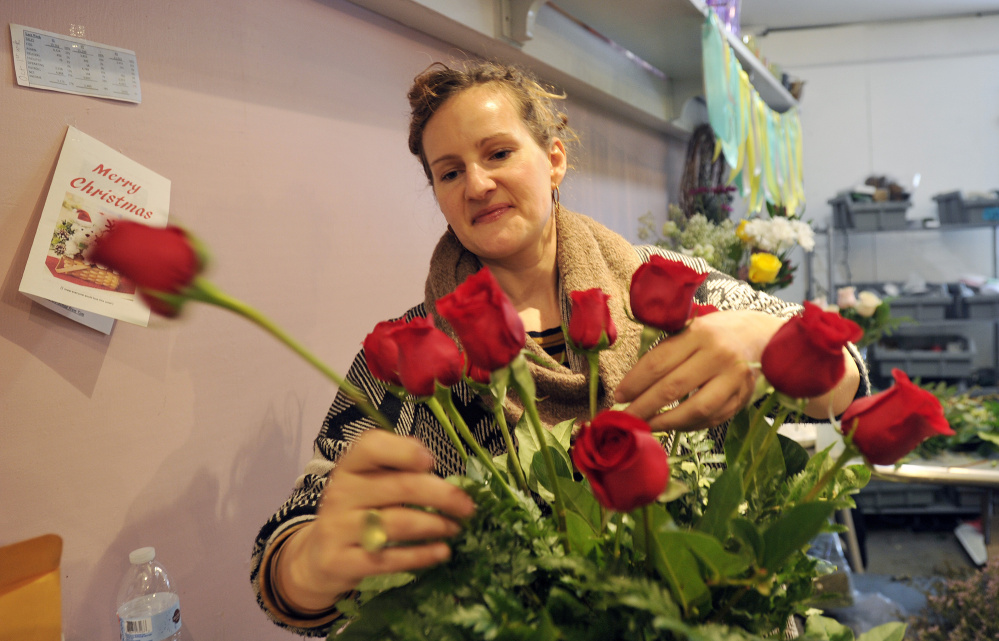 Designer Anne Heelan puts together a floral arrangement Monday at Harmon's & Barton's in preparation for Valentine's Day. Below, designer Jennifer Miller, right, and Heelan work on floral arrangements at Harmon's & Barton's ahead of Valentine's Day on Tuesday.