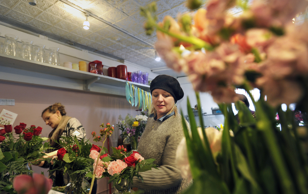 Staff photo by Shawn Patrick Ouellette
Designers Jennifer Miller, right, and Anne Heelan put together floral arrangements Monday at Harmon's & Barton's in preparation for Valentine's Day.