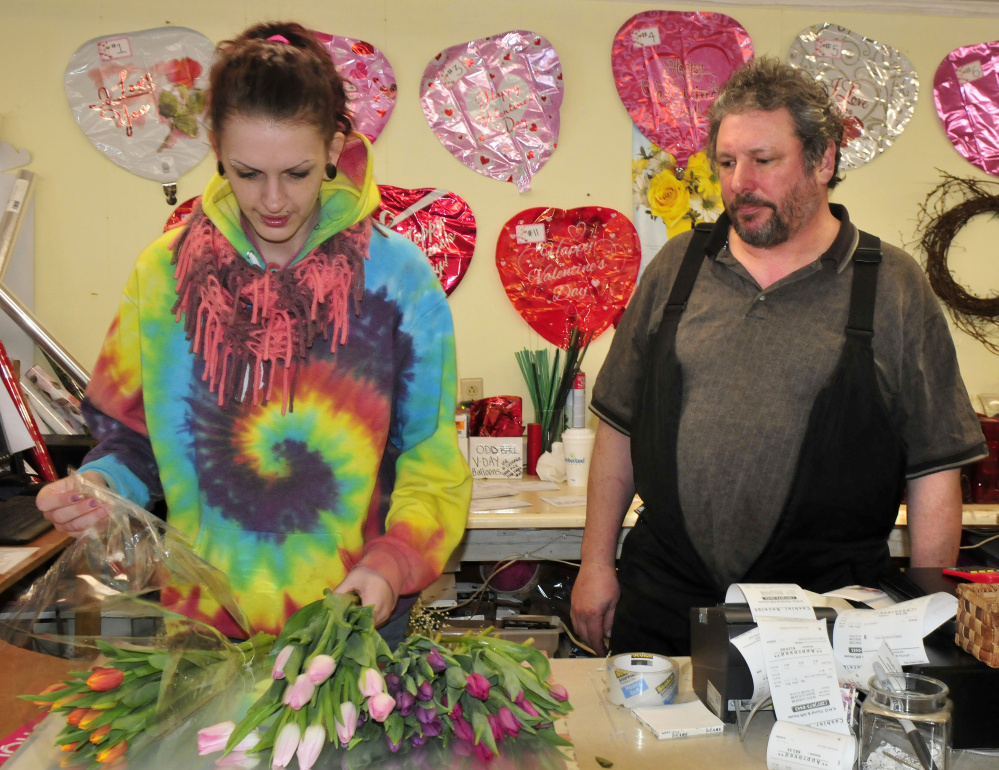 KMD Florist shop owner Dave Lagrange watches as employee Tavia Chamberlain makes a Valentine's Day bouquet at the Waterville business Monday. Maine florists are hoping for better conditions today to deliver flowers as it is one of the biggest days of the year for them.