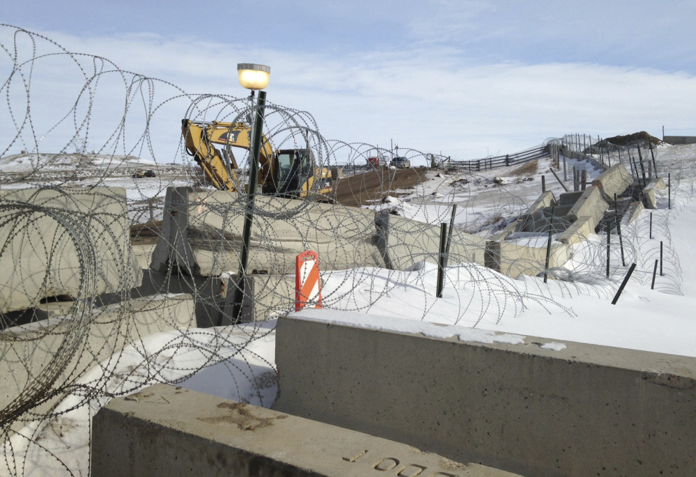 Razor wire and concrete barriers protect access to the Dakota Access pipeline drilling site Thursday near Cannon Ball, North Dakota. The developer says construction of the Dakota Access pipeline under a North Dakota reservoir has begun and that the full pipeline should be operational within three months.