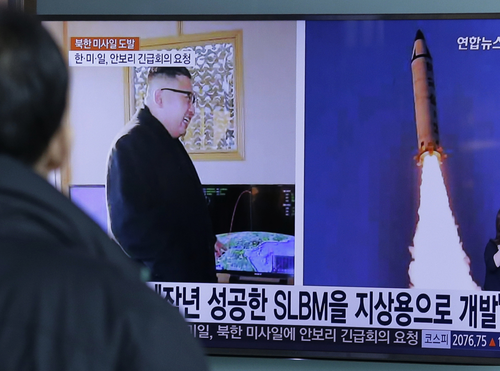 A man at Seoul Railway Station watches a program showing photos published in North Korea of the "Pukguksong-2" missile launch and North Korean leader Kim Jong Un.