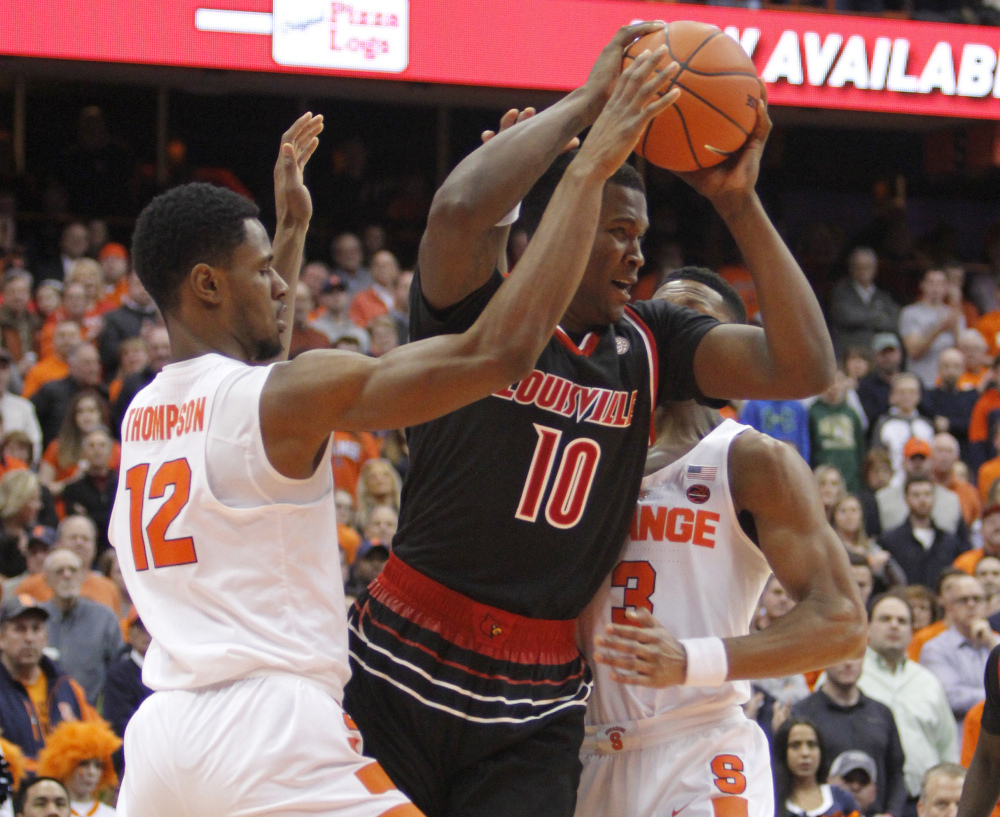 Louisville's Jaylen Johnson, center, is surrounded by Syracuse's Taurean Thompson, left, and Andrew White III, during a 76-72 Cardinals' win at Syracuse, N.Y., on Monday.