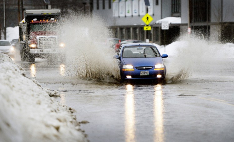 A motorist navigates a flooded stretch of Commercial Street in Portland on Wednesday as the city gets doused.