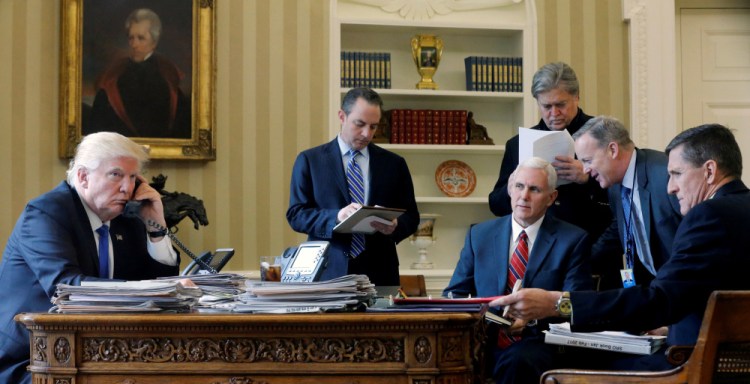 President Trump, joined by, from left, Chief of Staff Reince Priebus, Vice President Mike Pence, senior adviser Steve Bannon, Communications Director Sean Spicer and national security adviser Michael Flynn, works in the Oval Office on Jan. 28.