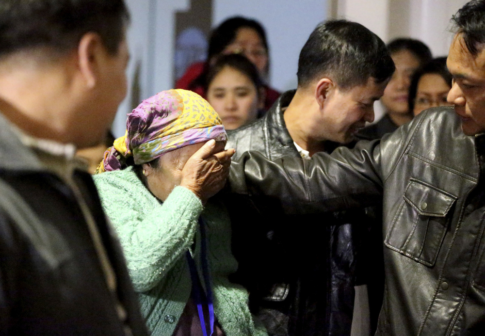 Thang Dim, left, a refugee from Myanmar, wipes away tears as her son Zam Piang, right, comforts her at Tulsa International Airport in Tulsa, Okla., on Tuesday. The first group of refugees arrived in Tulsa since a federal judge blocked President Trump's travel ban on refugees.