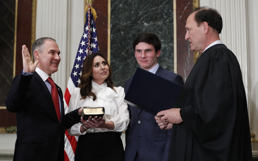 Supreme Court Associate Justice Samuel Alito swears in Scott Pruitt as the Environmental Protection Agency administrator in Washington on Friday. Holding the Bible is Marlyn Pruitt, wife of Scott Pruitt, as their son Cade Pruitt stands second from right.