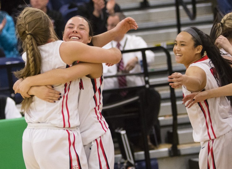 Scarborough players celebrate after their 42-38 win over Thornton Academy in a Class AA South girls' basketball quarterfinal Friday at the Portland Expo.