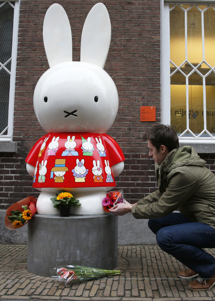 A man places flowers at Miffy's statue outside the Nijntje Museum, or Miffy Museum, in Utrecht, Netherlands, on Friday.