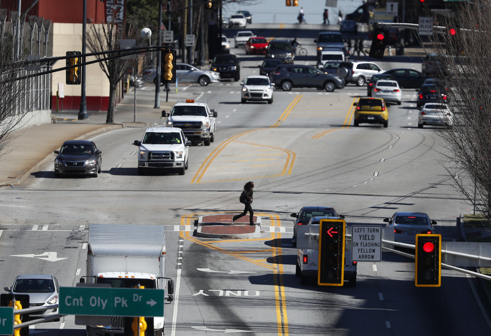 Pedestrians and cars move along a busy section of North Avenue near the Georgia Tech campus in Atlanta. This area might be a proving ground for driverless cars soon.