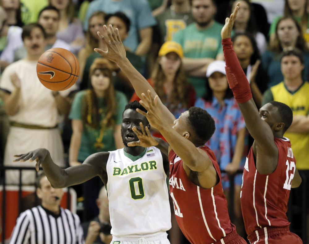 Baylor forward Jo Lual-Acuil Jr. passes the ball under pressure from Oklahoma's Dante Buford, center, and Khadeem Lattin during Baylor's 60-54 home win Tuesday.