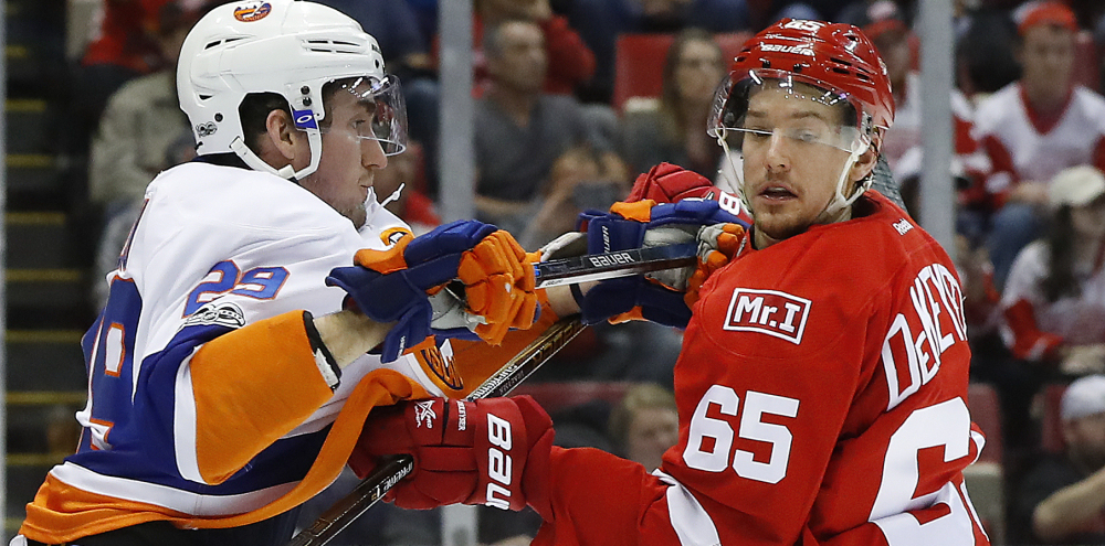 Brock Nelson of the Islanders and Detroit's Danny DeKeyser get their sticks up as they battle Tuesday night in Detroit.