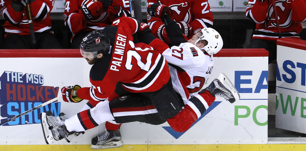 Kyle Palmieri of the Devils checks Ottawa's Curtis Lazar near the bench in the third period of Tuesday night's game at Newark, N.J. Ottawa, which was playing without three of its top six forwards, beat the Devils, 2-1.