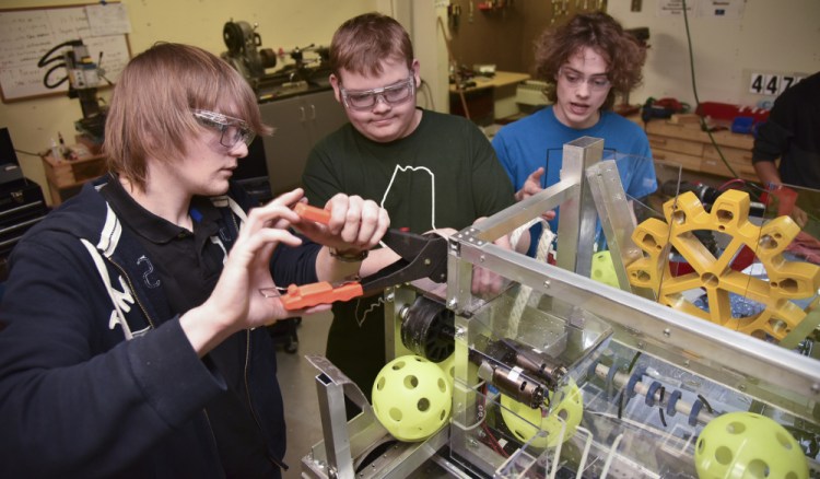 From left, Bryce Bragdon of Windsor, Michael Crochere of Chelsea and William Fahy of Hallowell put finishing touches on their robot Tuesday at the Ballard Center in Augusta.