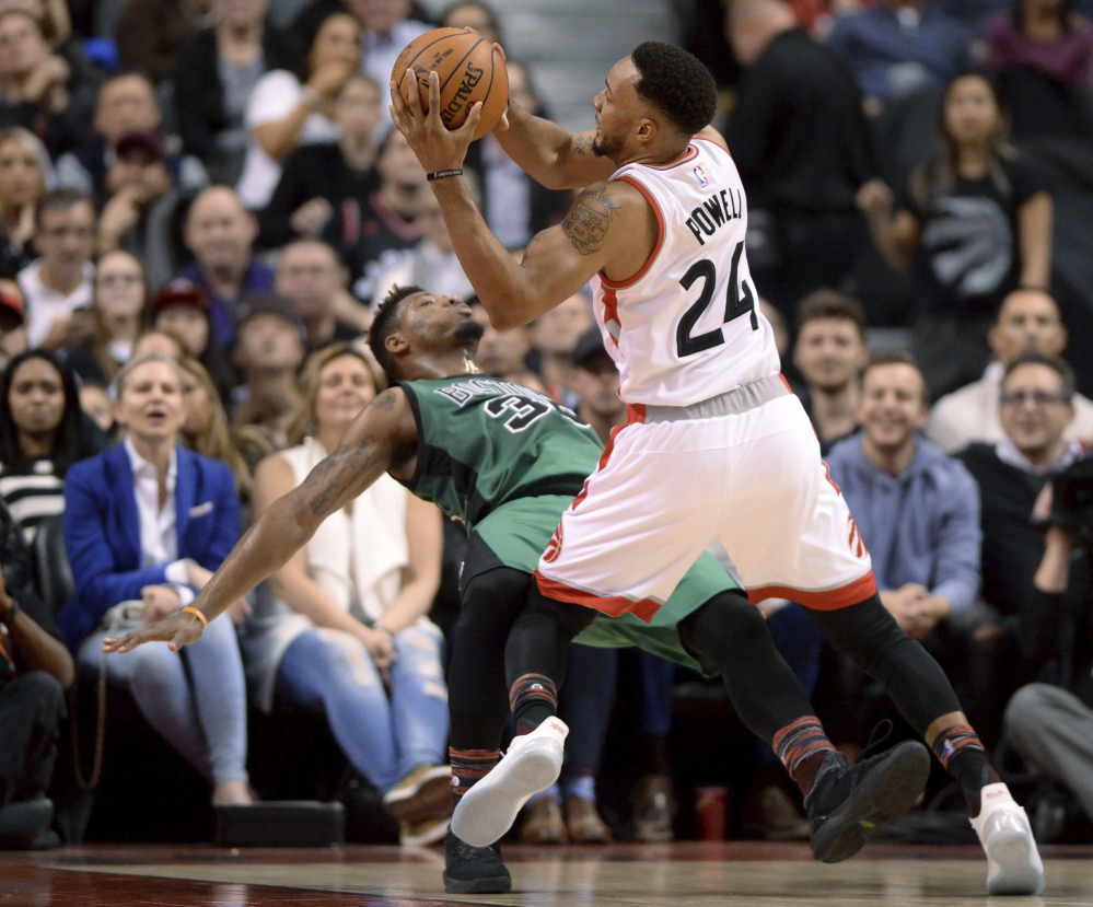 Toronto's Norman Powell collides with Boston's Marcus Smart and is called for charging in the first half of Friday night's game at Toronto.