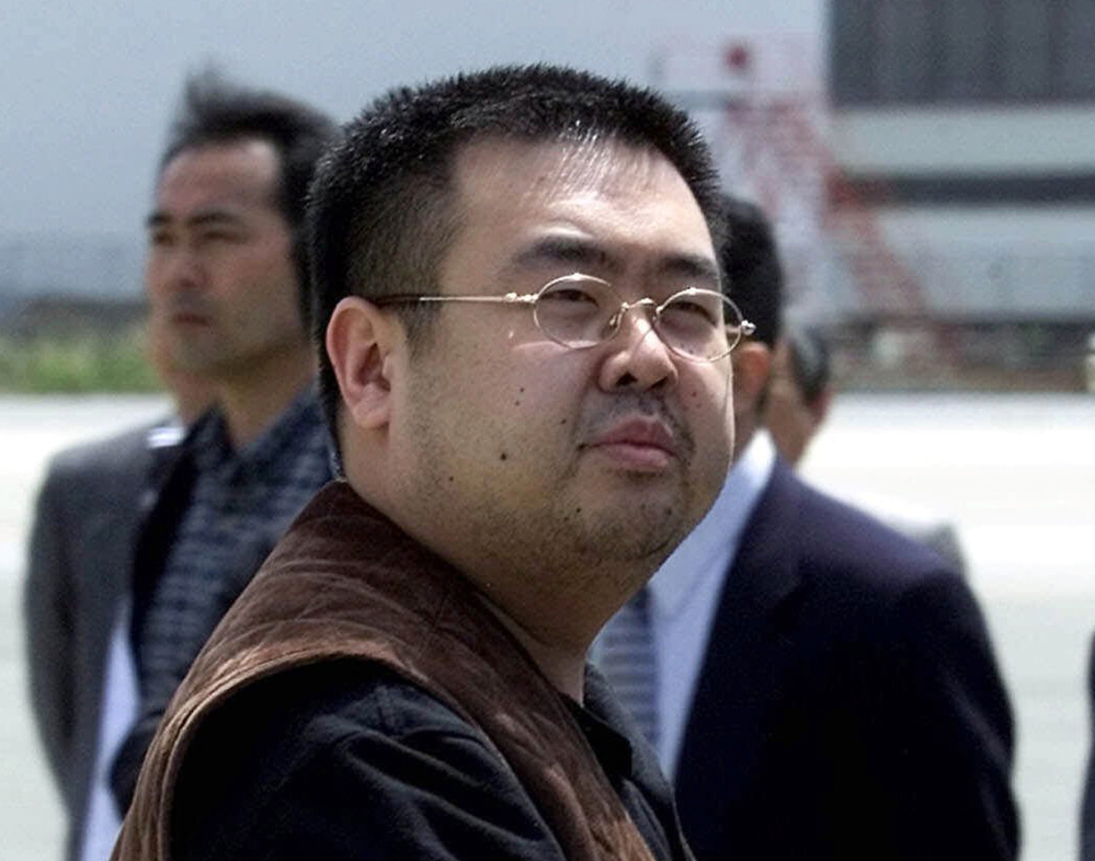 FILE - In this May 4, 2001, file photo, a man believed to be Kim Jong Nam, the eldest son of then North Korean leader Kim Jong Il, looks at a battery of photographers as he exits a police van to board a plane to Beijing at Narita international airport in Narita, northeast of Tokyo. Police in Malaysia say the half brother of North Korea's leader who was killed in a Kuala Lumpur airport more than a week ago had a nerve agent on his eye and his face. A statement Friday, Feb. 24, 2017 from the inspector general of police said that a preliminary analysis from the Chemistry Department of Malaysia identified the agent at "VX NERVE AGENT." (AP Photo/Shizuo Kambayashi, File)