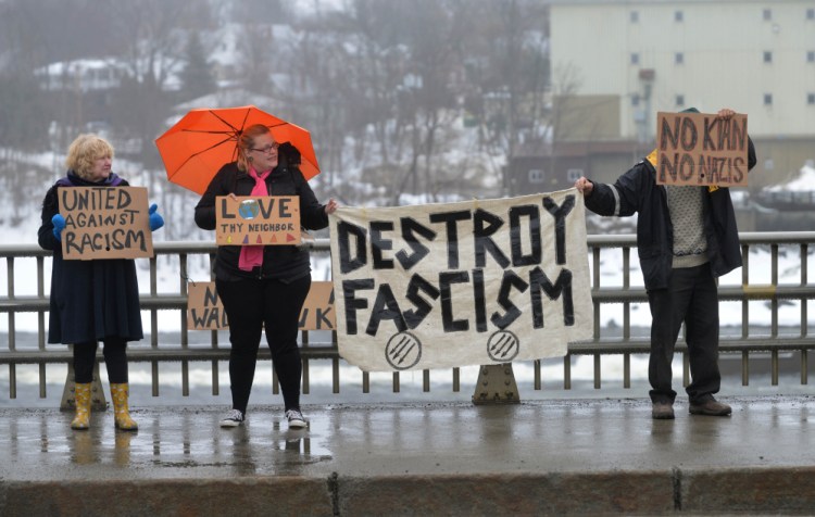 Protesters Beatrice Borden, far left, Serena Sanborn, left center and a man who would not identify himself stand on the Margaret Chase Smith Bridges in Skowhegan on Saturday to protest the Ku Klux Klan.