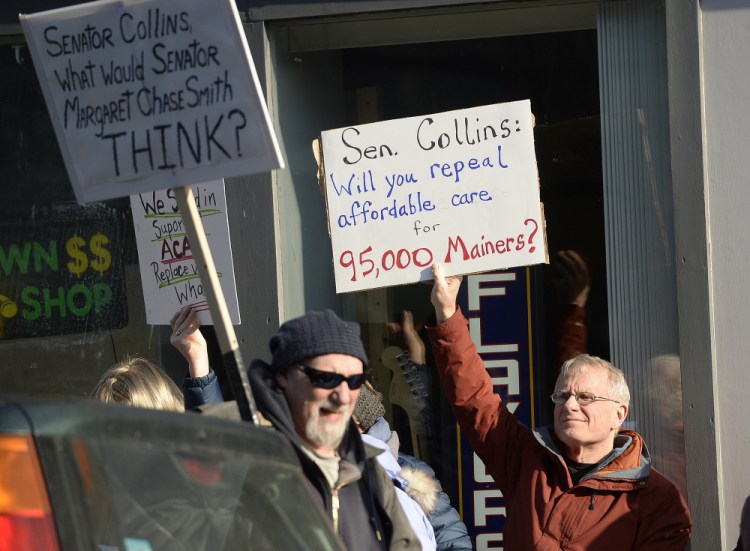 Henry Ingwersen, right, of Arundel holds a sign questioning Sen. Susan Collins' stance on Obamacare during the Biddeford demonstration last week. Though she eschews town-hall style gatherings, the senator says she held more than a dozen meetings and interviews with media and her constituents.