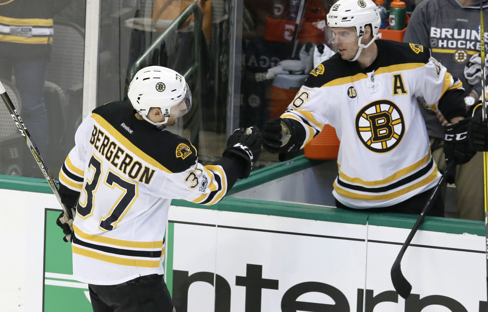 Boston Bruins center Patrice Bergeron (37) is congratulated by teammate David Krejci (46) after scoring during the second period against the Dallas Stars on Sunday in Dallas. The Bruins won 6-3. (Associated Press/LM Otero)