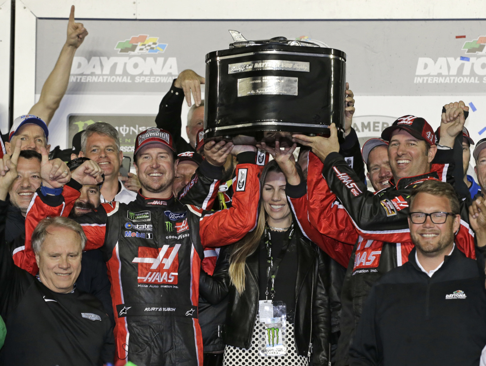 Kurt Busch, center left, and team members raise the trophy after Busch won the Daytona 500 Sunday at Daytona International Speedway in Daytona Beach, Fla.