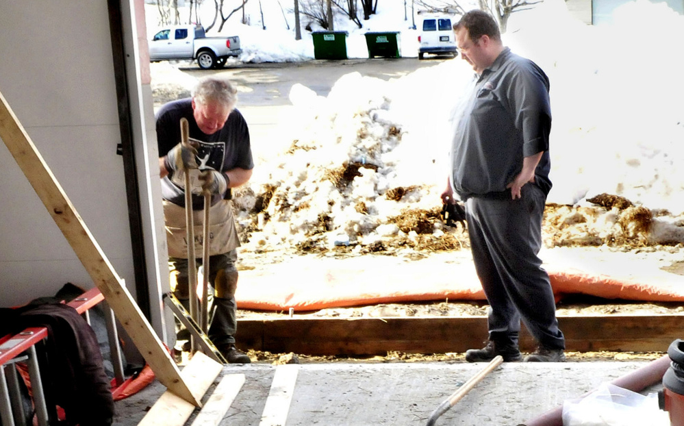 Chet Ficker, right, owner of Kennebec Express Lube, works with his father, Chris Ficker, to rebuild the floor. Their business, which will open again in March, is the only other car wash in Waterville.