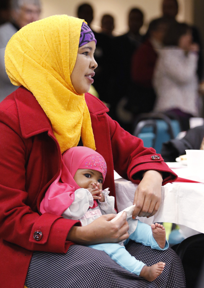 Hosna Sheikn of Lewiston holds her 3-month-old daughter, Ibtisam Afrah, during the dinner. Participants of all ages included refugees and other immigrants from Iraq, Lebanon, Somalia and the Democratic Republic of the Congo.