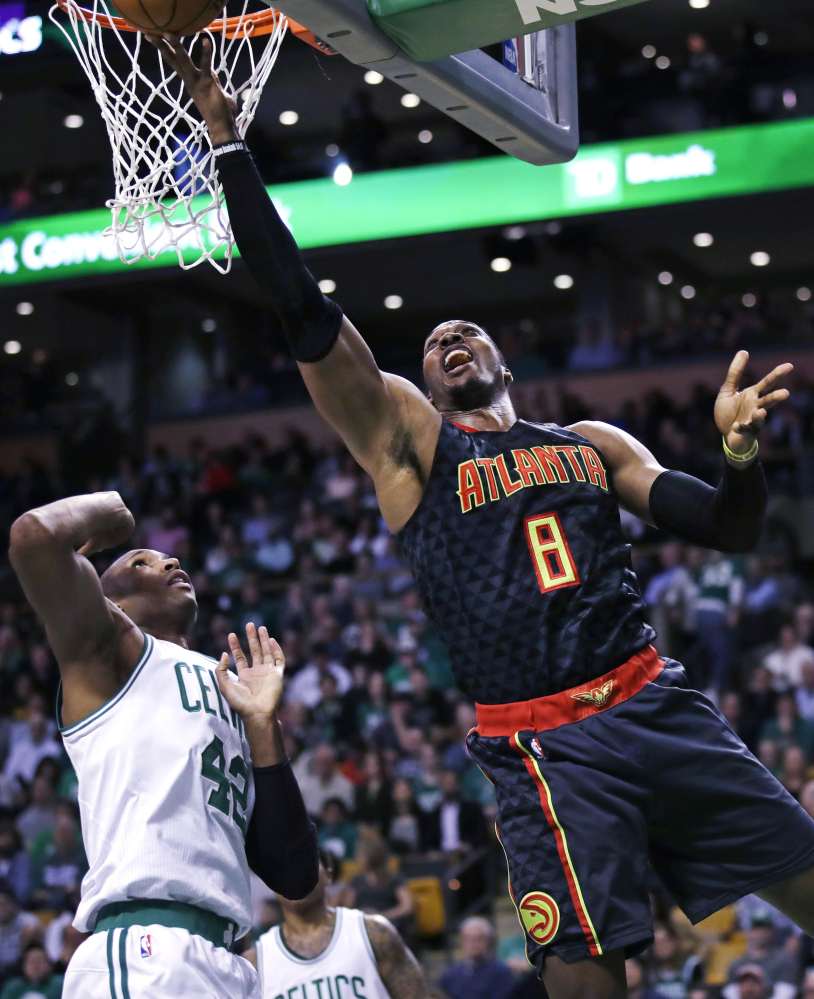 Atlanta center Dwight Howard drives past Celtics center Al Horford in the second quarter. Howard was ejected in the second half, but his ejection didn't keep Atlanta from routing the Celtics.