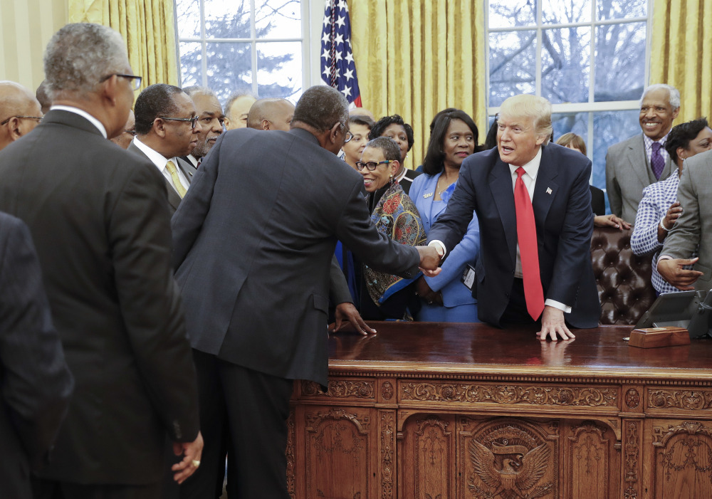 President Trump shakes hands with leaders of the nation's historically black colleges and universities in the Oval Office on Monday. Leaders of the schools were there to press their case for greater attention from the new Republican administration.