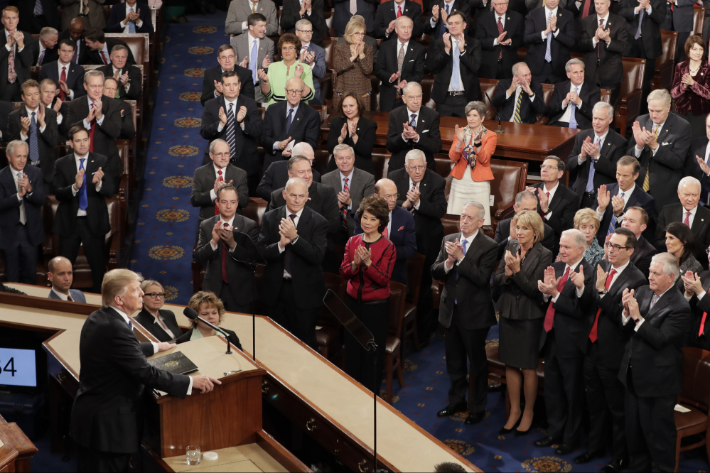 Republican lawmakers applaud President Trump during his speech. Democrats sat silently.