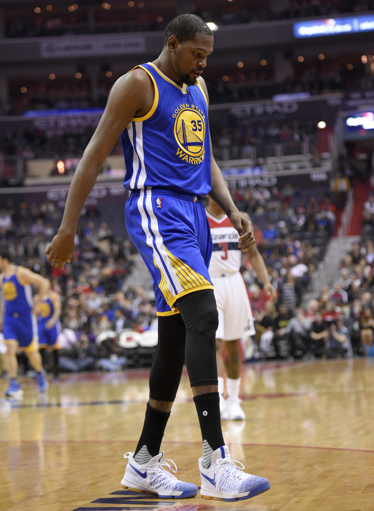 Kevin Durant of the Golden State Warriors heads to the bench after injuring his knee early in a loss Tuesday night at Washington. He will have an MRI done on the knee.