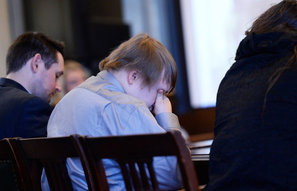 Dylan Collins covers his face as friends and family members of the victims speak at Collins' sentencing hearing Monday in York County Superior Court.