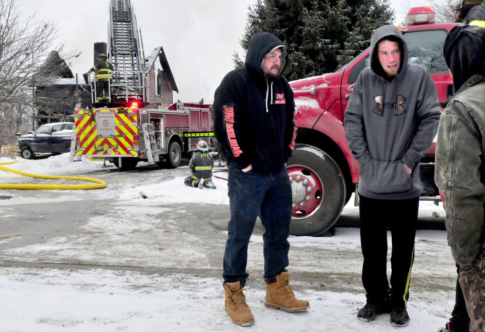 Tenants Joshua Lombard, left, and Jordan Ballard talk with friends as firefighters put out the fire that destroyed an apartment building on Square Road in Palmyra. 