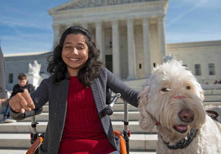 Ehlena Fry of Michigan and her service dog Wonder speaks to reporters outside the Supreme Court in Washington on Oct. 31, 2016.
