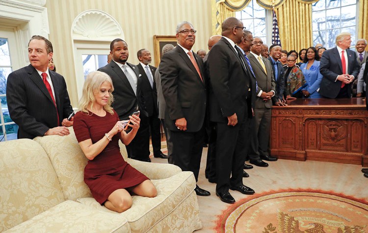 Counselor to the President Kellyanne Conway looks at her cellphone while President Trump meets with leaders of Historically Black Colleges and Universities in the Oval Office  Monday. Also at the meeting are White House Chief of Staff Reince Priebus, left.