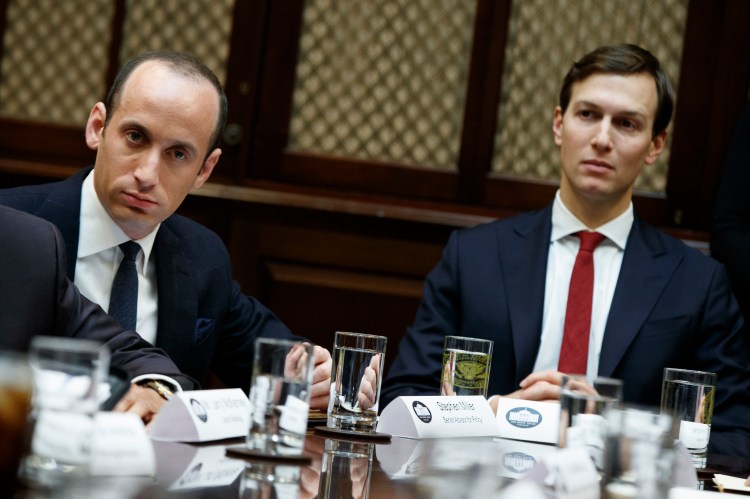 Senior White House adviser Stephen Miller, left, and Jared Kushner, President Trump's son-in-law, listen as Trump speaks during a meeting with business leaders in the White House on Jan. 30.