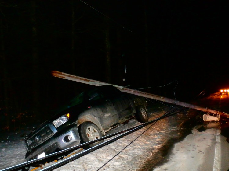 A pickup truck lies on the side of Route 25 in Limington after hitting a pole on Saturday.