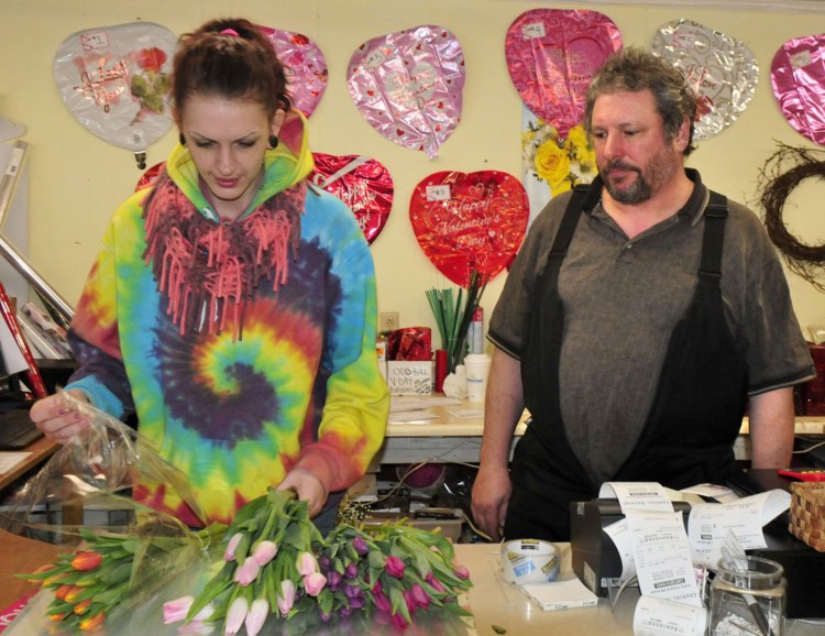 Dave Lagrange, who owns KMD Florist & Gift House in Waterville, watches as employee Tavia Chamberlain makes a Valentine's Day bouquet on Monday. “We’re going to see how much we can pack into one day that is usually spread over two days,” Lagrange said.