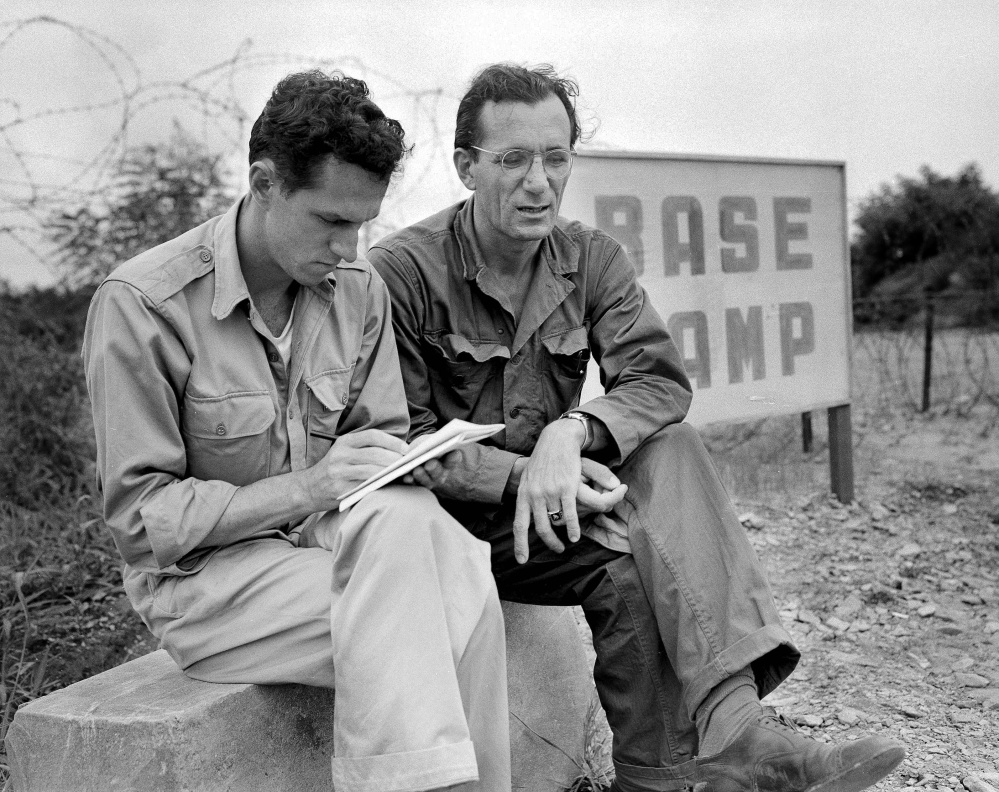 FILE - In this Aug. 1951 file photo, AP staffer Sam Summerlin, left, interviews Robert J. Santucci of Rochester, N.Y., a United Nations civilian stenographer who has been attending the Kaesong meetings, as they sit outside the entrance to the base camp at Munsan, Korea. Associated Press foreign correspondent Summerlin, who flashed the news to the world that the Korean War had ended and who reported on everything from Latin American revolutions to U.S. race riots during a long and distinguished career, has died at age 89. He died Monday, Feb. 27, 2017, at a care home in Carlsbad, Calif., from complications of Parkinson‚Äôs disease, according to his daughter, Claire Slattery of Encinitas, Calif. (AP Photo/Bob Schutz, File)