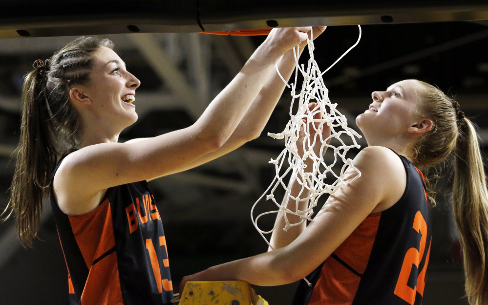Aidan Sachs, left, and Brooke Barter share the honor of cutting the final strands of the net after Brunswick beat Greely to win the Class A South final.