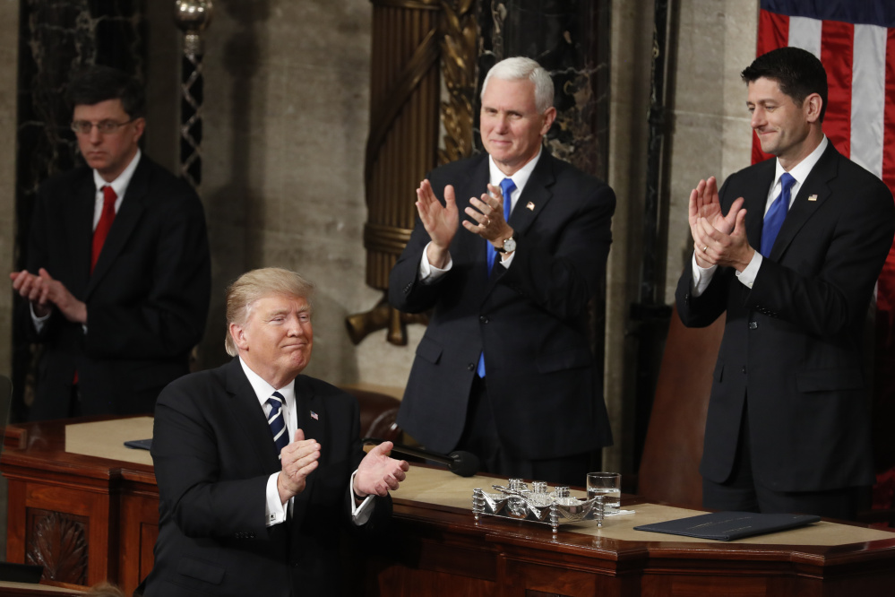 Vice President Mike Pence and House Speaker Paul Ryan applaud as President Trump concludes his speech to Congress on Tuesday. Trump won high marks from Republicans for his agenda and his measured tone.