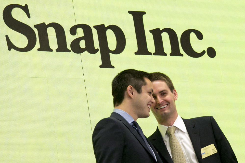Snapchat co-founders Bobby Murphy, left, and CEO Evan Spiegel ring the opening bell at the New York Stock Exchange as the company celebrates its initial public stock offering on Thursday.