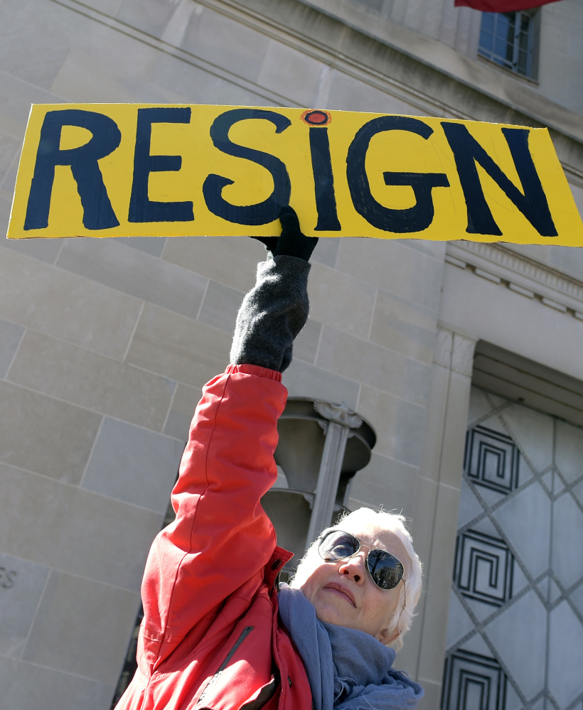 Cheryl Kreiser of Silver Spring, Md., holds up a sign outside the Justice Department in Washington, Thursday, as she joined a group to protest Attorney General Jeff Sessions.