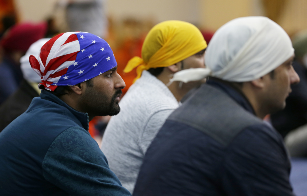 A man wears a head covering with the stars and stripes of a U.S. flag as he attends Sunday services at the Gurudwara Singh Sabha of Washington, a Sikh temple in Renton, Wash.
